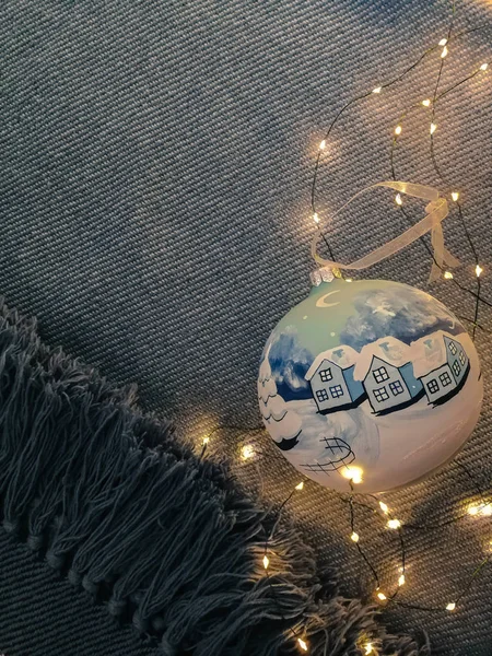 Noel ve Yeni Yıl 'ın güzel bir geçmişi var. Noel ağacı oyuncağı ve öncü ışıklar yumuşak ve rahat mavi halıda. Mavi örülmüş kumaş arka plan ve elle boyanmış Noel ağacı topu.  