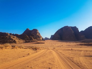 Kamyonette safari gezisi. Kumda lastik izleri. Ürdün 'deki doğa parkı ve rezervi. Wadi Rum çölünün manzaralı manzaraları.. 