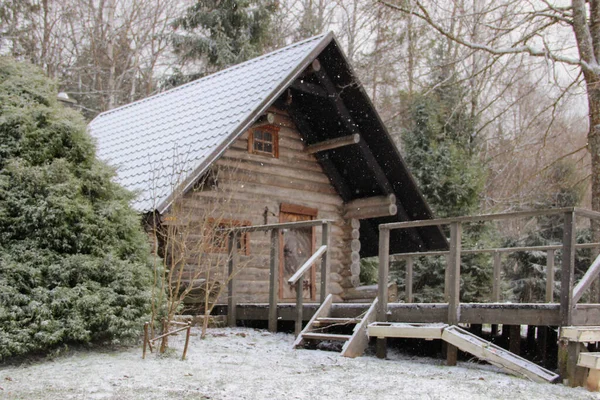 Kar odaklı İdilik kır evi manzaralı. Binanın önündeki odunluk ve ahşap güverte..