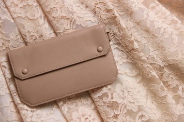 Uyumlu çantalı dantelli elbise parçası. Dantel arkaplan üzerinde bej zarf çanta.