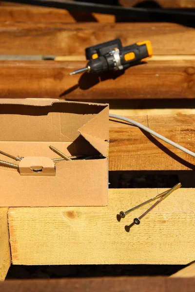 Arka planda vida kutusu ve elektrikli tornavida var. Arka bahçe verandası yenilemesi. 