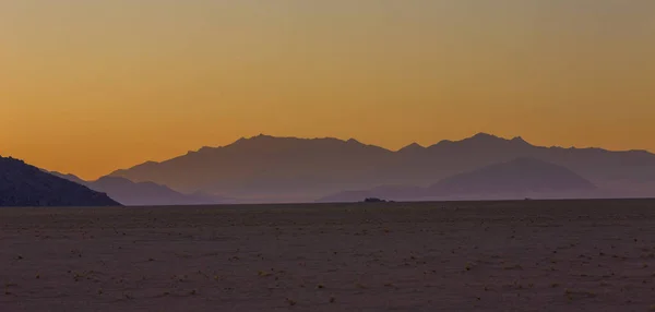 Жовтого кольору небо і сині далекі гори після заходу сонця — стокове фото