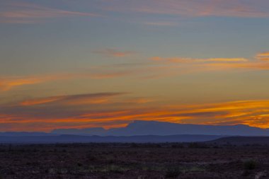 Ufuktaki mavi dağların üzerinde gökyüzü renkli sarı ve turuncu