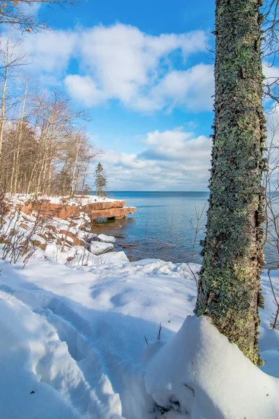 Kuzey Wisconsin 'deki Madeline Adası' ndaki Big Bay State Park 'ta soğuk ve kar altında güzel ağaçlar ve Superior Gölü kıyıları mavi gökyüzüyle güneşli bir gün.