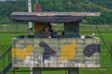 DMZ / SOUTH KOREA - JUNE 21, 2013: Armed guards on duty at lookout at the DMZ on South Korean side of conflict clipart
