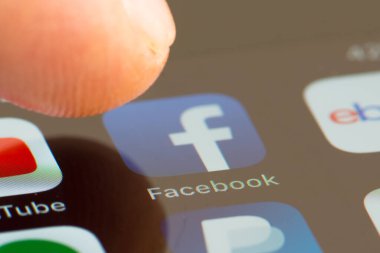 MINNEAPOLIS, MINNESOTA / USA - 25 Nisan 2019: Apple i-phone kullanarak Facebook uygulamasına / uygulamasına erişen kişi