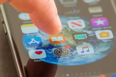 MINNEAPOLIS, MINNESOTA / USA - 25 Nisan 2019: Apple i-phone kullanarak Kitap uygulamasına / uygulamasına erişen kişi