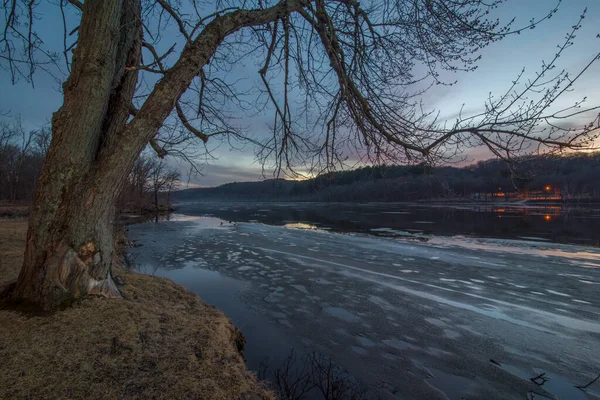 Wide angle view of the vast St. Croix River on a frosty winter sunset / early evening - river separating Wisconsin and Minnesota - beautiful clouds and ice chunks in river