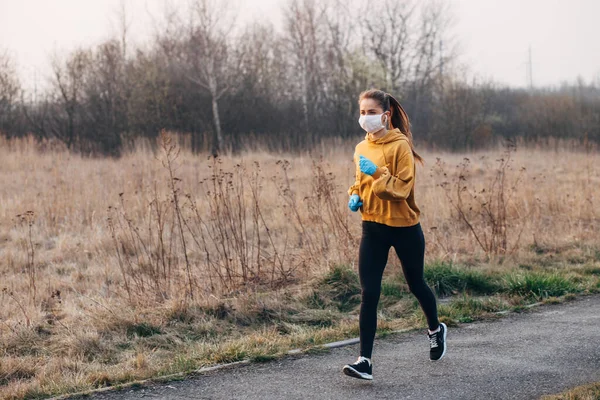 COVID-19 Pandemic Coronavirus girl in mask and blue gloves during quarantine went out to run