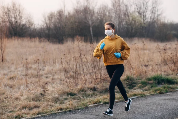 COVID-19 Pandemic Coronavirus girl in mask and blue gloves during quarantine went out to run