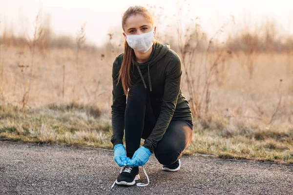 COVID-19 Pandemic Coronavirus girl in mask and blue gloves during quarantine went out to run