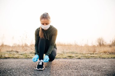 COVID-19 Pandemic Coronavirus kızı maskeli ve mavi eldivenli karantina sırasında dışarı çıktı.