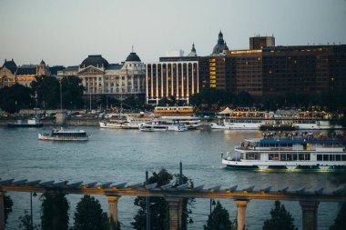 Tuna Nehri 'ndeki Budapeşte şehrinin gece manzarası. Üzerinde açık köprü ve parlamento bulunan gemiler yelken açıyor.
