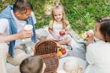 Aile piknikte meyve yiyip içiyor..