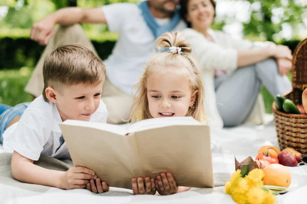 Dzieci czytające książkę podczas pobytu w parku. — Zdjęcie stockowe