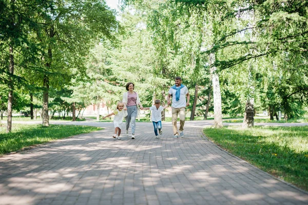 Große Familie mit zwei Kindern spazieren im Park. — Stockfoto