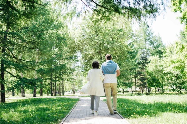 Getrouwd echtpaar van middelbare leeftijd wandelend in het park. — Stockfoto