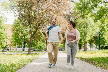 Park yolunda kameraya poz veren orta yaşlı bir çift..