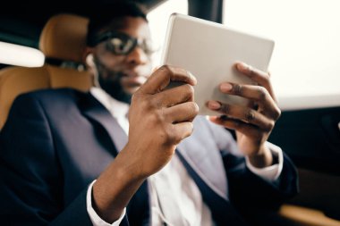 Adam araba kullanırken tabletle oynuyor..