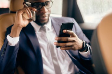 Arka koltuktaki adam telefon ekranına bakıyor..