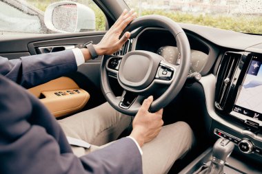 Şoför direksiyonu tutup arabasını sürmeye hazır..