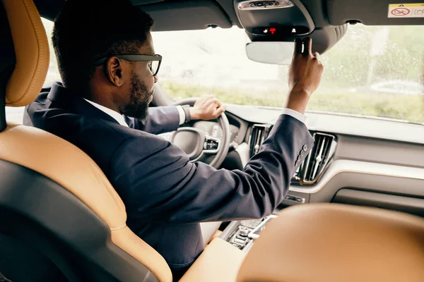 Uomo alla guida della sua auto e guardando lo specchio posteriore . — Foto Stock