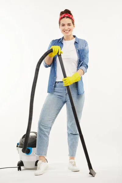 Pretty woman in work-wear uses a big wacuum cleaner. — Stock Photo, Image