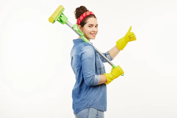 Mujer bonita en ropa de trabajo sostiene una fregona de piso amarillo . — Foto de Stock