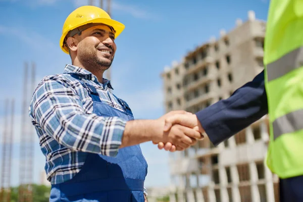 Dos ingenieros masculinos se dan la mano amistosamente . — Foto de Stock