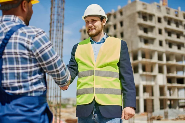 Zwei männliche Ingenieure schütteln einander freundlich die Hand. — Stockfoto