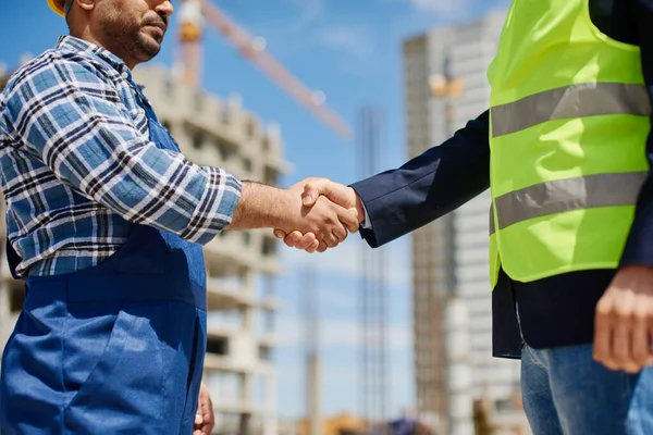 Dos ingenieros masculinos se dan la mano amistosamente . — Foto de Stock