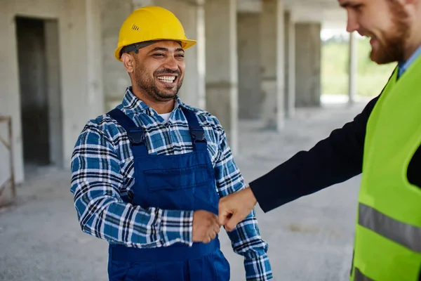 Dos ingenieros discuten juntos cuestiones relacionadas con el trabajo, ambos sonríen mirándose . — Foto de Stock