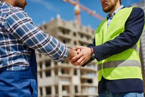 Dos ingenieros masculinos se dan la mano amistosamente . — Foto de Stock