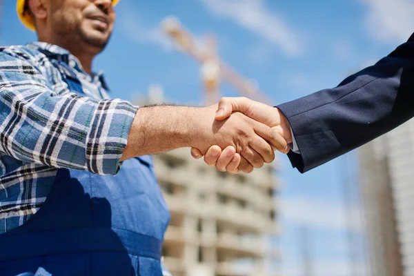 Due ingegneri maschi si stringono le mani amichevoli . Foto Stock