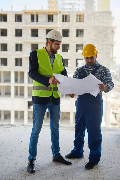 Nahaufnahme eines Bauplans, den zwei Ingenieure untersuchen. — Stockfoto