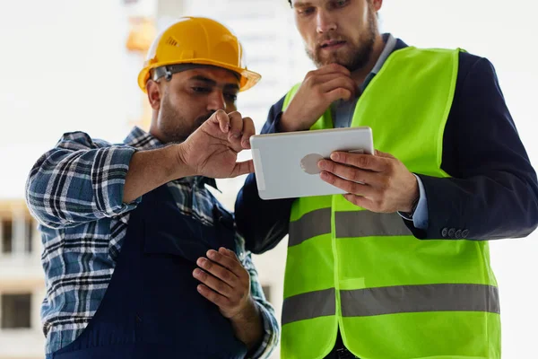 Dois engenheiros discutem questões relacionadas ao trabalho em conjunto . — Fotografia de Stock