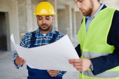 İki mühendisin incelediği bir planın yakın çekim.