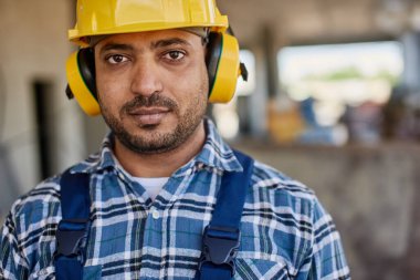 Sarı inşaat kask gülümseyen mühendis kamera bakıyor.