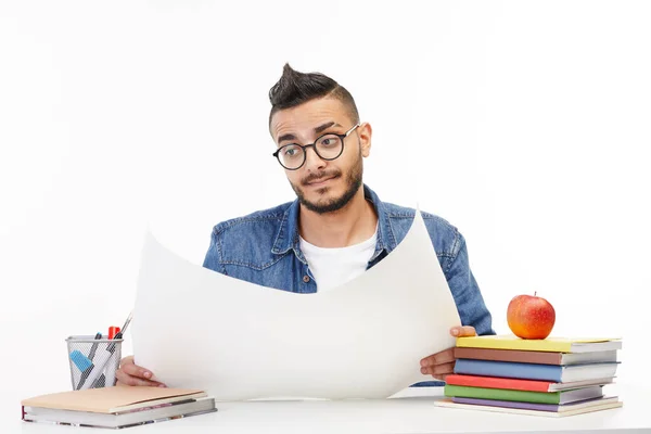 Estudiante universitario lee lo que está escrito en una hoja grande de papel . —  Fotos de Stock