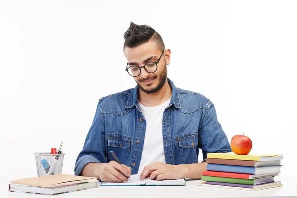 Schüler schreibt in sein Lehrbuch in der Klasse. — Stockfoto