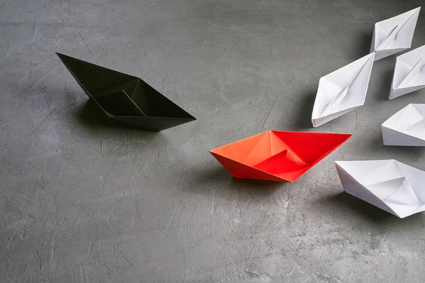 Business leadership Concept, the key opinion Leader, the concept of influence.Opportunities Business Concept-Paper Boat key opinion Leader, influence concept. One black paper boat as a Leader, leading