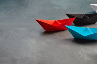 Fırsatlar Liderliği İş Konsepti-Kağıt-Tekne anahtar fikir lideri, konsepti etkileme. Lider olarak bir siyah kağıt tekne, beyaz gemilere doğru gidiyor ve kırmızı kağıt boa ile buluşuyor.