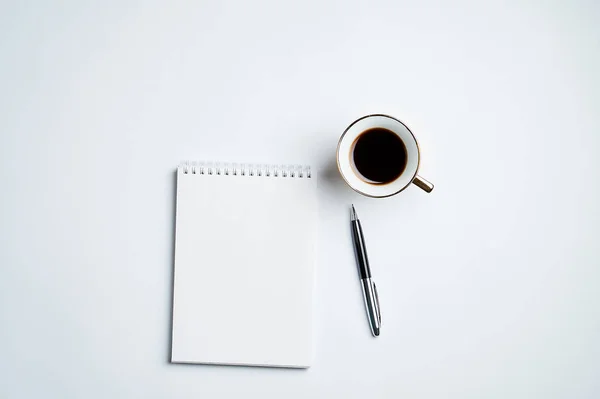 Escritório branco Desk vista superior com Bloco de notas, caneta e xícara de café, design minimalista, vista superior, espaço de cópia, flat lay — Fotografia de Stock
