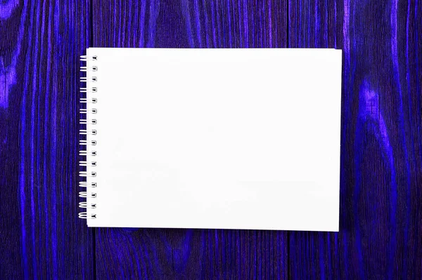 White office Notepad lies on a bright phantom blue colored wooden background, minimalistic design, top view, flat lay, copy space — 스톡 사진