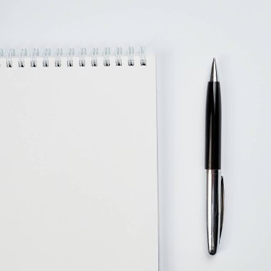 Notepad ve kalem ile beyaz ofis masaüstü görünümü, minimal tasarım, üst görünüm, kopyalama alanı, düz uzanma