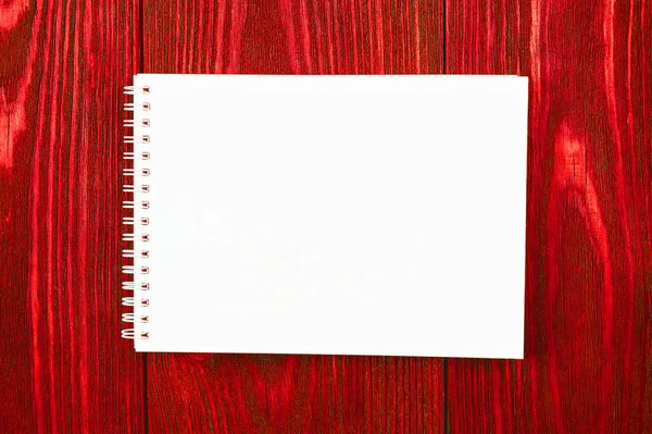 Beyaz ofis notları parlak kırmızı ahşap bir zemin üzerinde uzanır, minimal tasarım, üst görünüm, düz yatış, kopyalama alanı