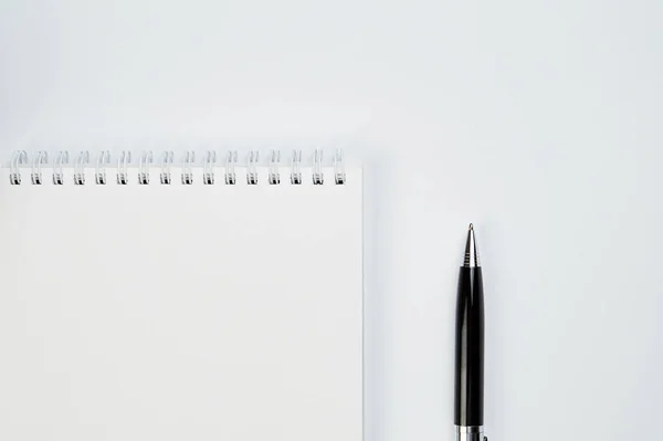 Wit bureau bovenaanzicht met schrijfblok en pen, minimalistisch design, bovenaanzicht, kopieerruimte, platte lay — Stockfoto