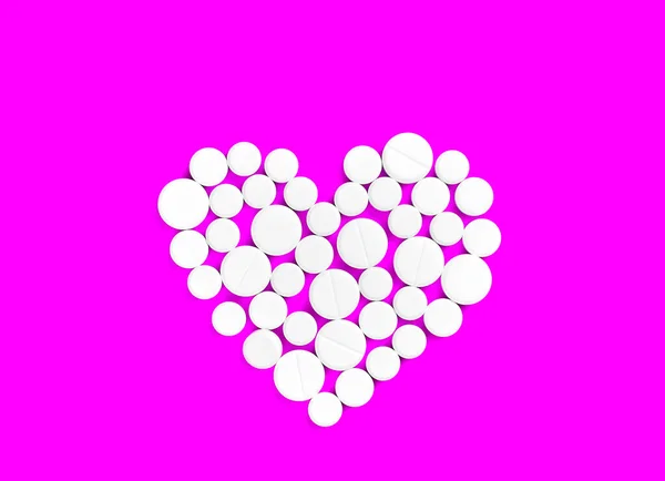 White medicine pills in the shape of a heart on a pink background top view with copy space