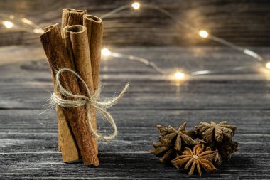 Kapalı bir demet tarçın ve ahşap arka planda yıldız anason bileşimi. Yumuşak şarap için tatil baharatları.