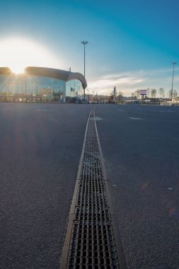 Şehirde çok büyük ve uzun bir kanalizasyon ızgarası, büyük asfalt bir alanın ortasında yağmur fırtınası. sel koruması.